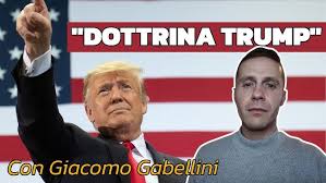 “Dottrina Trump” Un uomo punta verso l'alto accanto a un altro uomo con una bandiera statunitense sullo sfondo e la scritta Dottrina Trump sopra di loro.